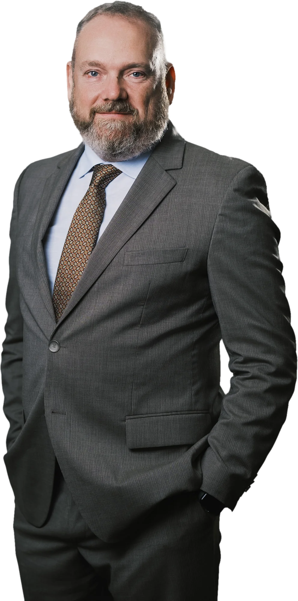 Neil Gannon in a charcoal suit, standing three-quarter to camera