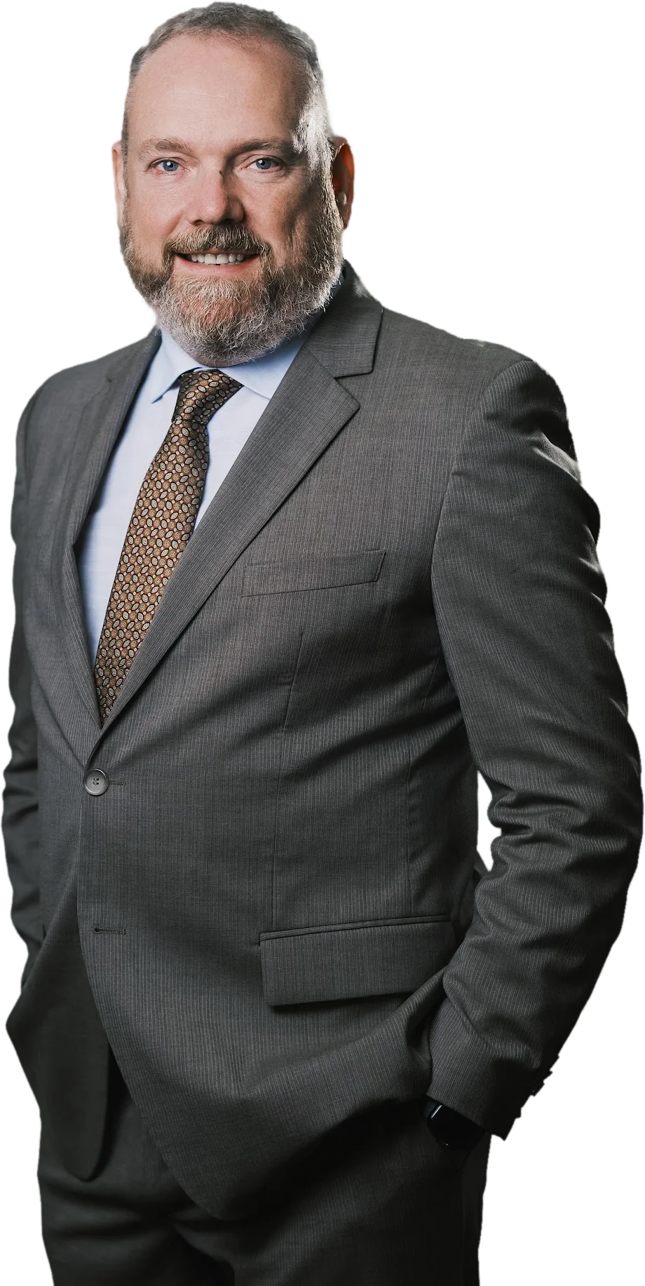 Neil Gannon smiling, hands in pockets, three-quarter to camera